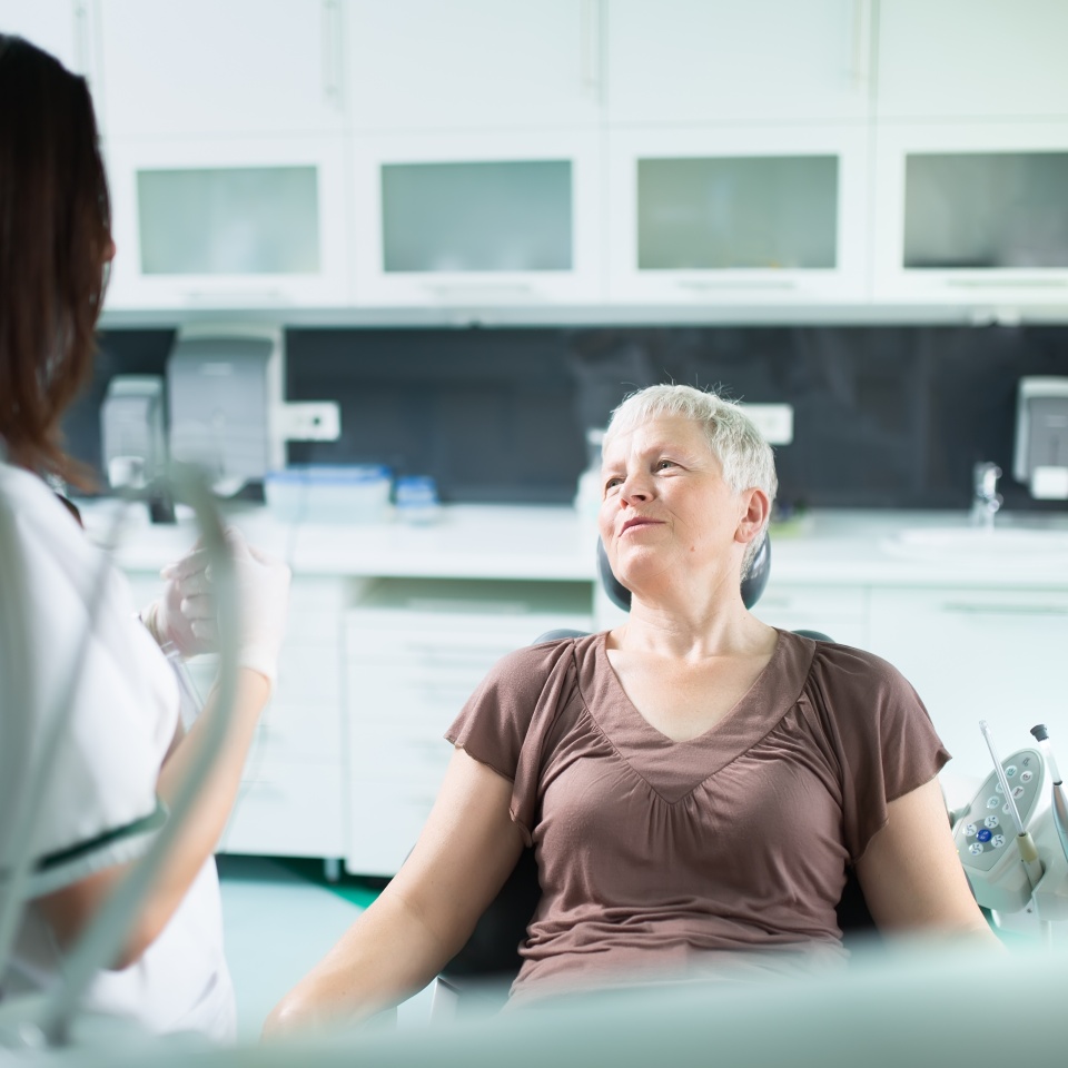 Old woman visiting the dentist taking care of her teeth.Dentist doctor talking to a senior woman patient.Dental care for elder.Prosthodontics and oral protesis