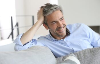 Smiling handsome 45-year-old man relaxing at home