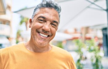Middle age grey-haired man smiling happy walking at street of city.