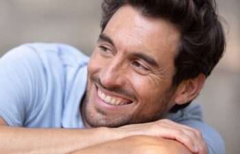 young man relaxing on park bench on a summers day