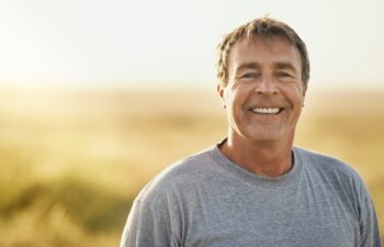 Senior man, smile and portrait at field in summer for outdoor adventure, nature and holiday. Sunshine, happy and face of person by mockup space for weekend vacation, peace and tourism in Turkey