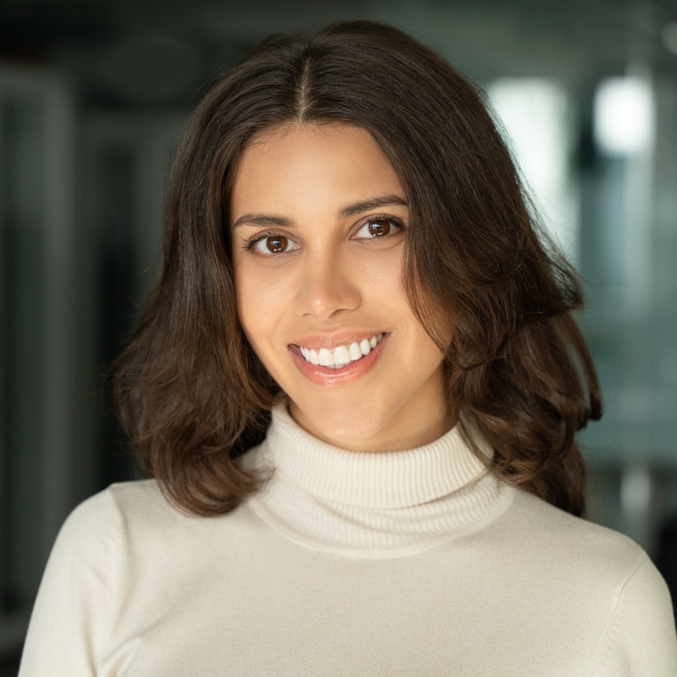 Closeup headshot face portrait of beautiful successful hispanic young business woman looking confident at camera. Smiling latin or eastern middle age female ceo leader businesswoman standing in office